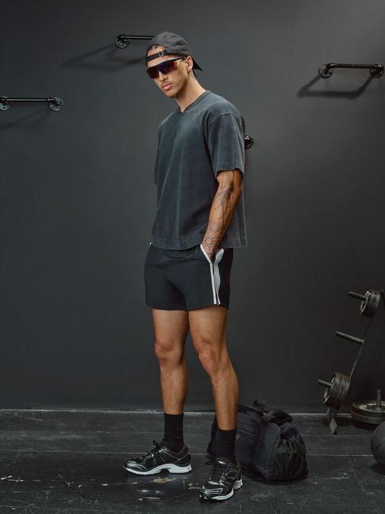 Man in athletic wear standing in a gym with weights in the background